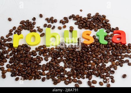 Chicchi di caffè arrosto robusta sullo sfondo del tavolo. Chicchi di caffè freschi. Messa a fuoco selettiva Foto Stock