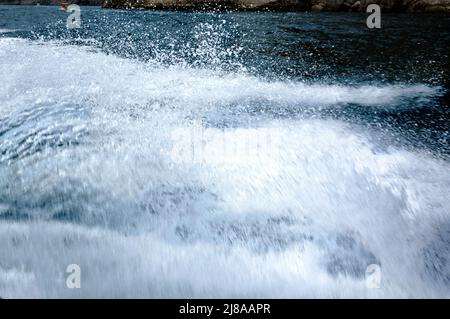 Spruzzi d'acqua da una barca galleggiante. Mar Nero, giorno d'estate. Foto Stock