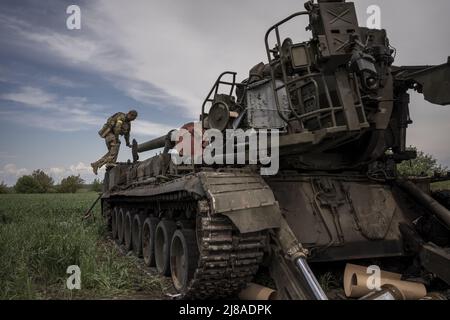 Vilhivka, Ucraina. 14th maggio 2022. I soldati ucraini arrivano sulla scena di un Pion ucraino distrutto 2S7 (Peony), carro armato che giace in un campo da russo sgusciando la notte prima ad est di Kharkiv a Vilhivka, Ucraina, sabato 14 maggio 2022. Le forze russe si stanno ritirando dalla città Ucraina settentrionale, precedentemente occupata, di Kharkiv, i funzionari militari hanno dichiarato sabato, mentre Kyiv ha lanciato una controffensiva nella vicina città di Izium. Foto di Ken Cedeno/UPI Credit: UPI/Alamy Live News Foto Stock