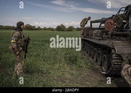 Vilhivka, Ucraina. 14th maggio 2022. I soldati ucraini arrivano sulla scena di un Pion ucraino distrutto 2S7 (Peony), carro armato che giace in un campo da russo sgusciando la notte prima ad est di Kharkiv a Vilhivka, Ucraina, sabato 14 maggio 2022. Le forze russe si stanno ritirando dalla città Ucraina settentrionale, precedentemente occupata, di Kharkiv, i funzionari militari hanno dichiarato sabato, mentre Kyiv ha lanciato una controffensiva nella vicina città di Izium. Foto di Ken Cedeno/UPI Credit: UPI/Alamy Live News Foto Stock