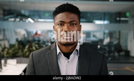 Primo piano ritratto African american giovane imprenditore investitore fiducioso maschio volto concentrato espressione guardando fotocamera seriamente uomo Foto Stock