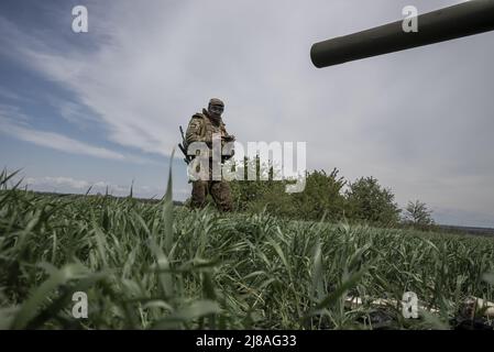 Vilhivka, Ucraina. 14th maggio 2022. I soldati ucraini arrivano sulla scena di un Pion ucraino distrutto 2S7 (Peony), carro armato che giace in un campo da russo sgusciando la notte prima ad est di Kharkiv a Vilhivka, Ucraina, sabato 14 maggio 2022. Le forze russe si stanno ritirando dalla città Ucraina settentrionale, precedentemente occupata, di Kharkiv, i funzionari militari hanno dichiarato sabato, mentre Kyiv ha lanciato una controffensiva nella vicina città di Izium. Foto di Ken Cedeno/UPI Credit: UPI/Alamy Live News Foto Stock