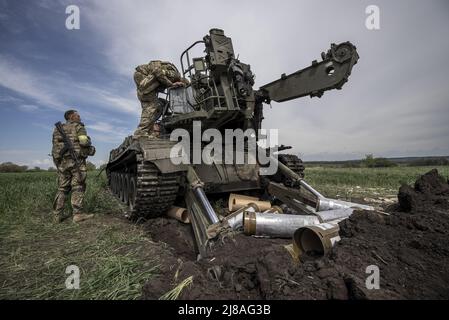 Vilhivka, Ucraina. 14th maggio 2022. I soldati ucraini arrivano sulla scena di un Pion ucraino distrutto 2S7 (Peony), carro armato che giace in un campo da russo sgusciando la notte prima ad est di Kharkiv a Vilhivka, Ucraina, sabato 14 maggio 2022. Le forze russe si stanno ritirando dalla città Ucraina settentrionale, precedentemente occupata, di Kharkiv, i funzionari militari hanno dichiarato sabato, mentre Kyiv ha lanciato una controffensiva nella vicina città di Izium. Foto di Ken Cedeno/UPI Credit: UPI/Alamy Live News Foto Stock