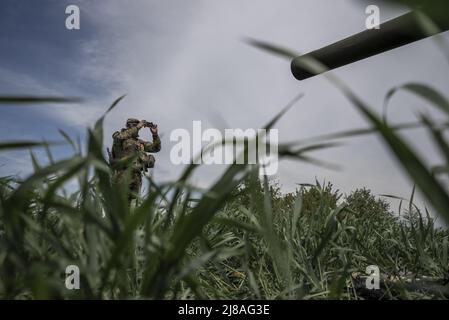 Vilhivka, Ucraina. 14th maggio 2022. I soldati ucraini arrivano sulla scena di un Pion ucraino distrutto 2S7 (Peony), carro armato che giace in un campo da russo sgusciando la notte prima ad est di Kharkiv a Vilhivka, Ucraina, sabato 14 maggio 2022. Le forze russe si stanno ritirando dalla città Ucraina settentrionale, precedentemente occupata, di Kharkiv, i funzionari militari hanno dichiarato sabato, mentre Kyiv ha lanciato una controffensiva nella vicina città di Izium. Foto di Ken Cedeno/UPI Credit: UPI/Alamy Live News Foto Stock