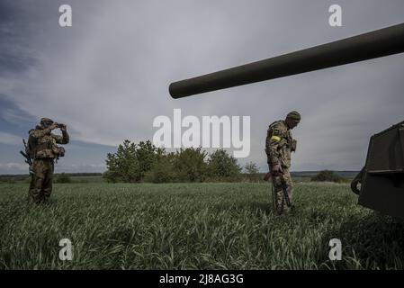 Vilhivka, Ucraina. 14th maggio 2022. I soldati ucraini arrivano sulla scena di un Pion ucraino distrutto 2S7 (Peony), carro armato che giace in un campo da russo sgusciando la notte prima ad est di Kharkiv a Vilhivka, Ucraina, sabato 14 maggio 2022. Le forze russe si stanno ritirando dalla città Ucraina settentrionale, precedentemente occupata, di Kharkiv, i funzionari militari hanno dichiarato sabato, mentre Kyiv ha lanciato una controffensiva nella vicina città di Izium. Foto di Ken Cedeno/UPI Credit: UPI/Alamy Live News Foto Stock