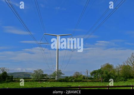 Bridgwater, Regno Unito. 13th maggio 2022. In un pomeriggio di sole ventoso e caldo, i primi piloni di energia elettrica New Shape T appena installati sono visti attraverso il paesaggio verde di Rooksbridge nel Somerset Nord, che viene messo a fornire energia dalla rete Nazionale. Picture Credit: Robert Timoney/Alamy Live News Foto Stock