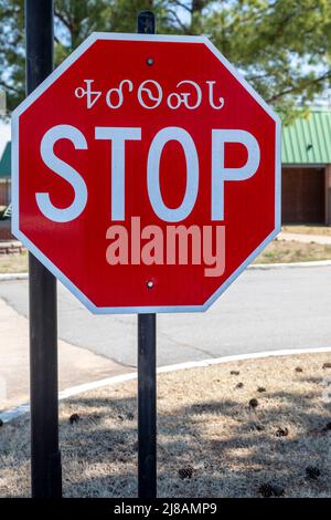 Tahlequah, Oklahoma - un segnale di stop in inglese e Cherokee nella città nord-orientale dell'Oklahoma, dove ha sede la nazione Cherokee. Foto Stock