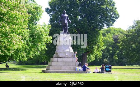 Persone rilassarsi accanto a una statua di Oliver Cromwell in Wythenshawe Park, South Manchester, Inghilterra, Regno Unito, Isole britanniche, Europa. Foto Stock