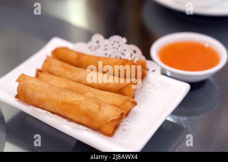 Involtini primavera fritti cinesi su piatto bianco Foto Stock