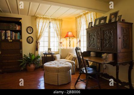 Poltrona imbottita e ottomana, scrivania segretario in camera studio all'interno di una vecchia casa in stile cottage del 1705 circa. Foto Stock