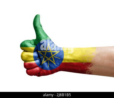 Mano facendo pollice su dipinto con bandiera di etiopia Foto Stock