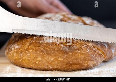 Pane fresco sul tavolo da cucina, lo chef fette di pane bianco. Il concetto di alimentazione sana. Cottura del pane. Foto Stock
