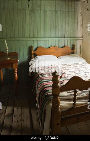 Letto antico e tavolo da notte in camera da letto all'interno del vecchio regime francese 1730 Maison Drouin, Sainte-Famille, Ile d'Orleans, Quebec, Canada. Foto Stock