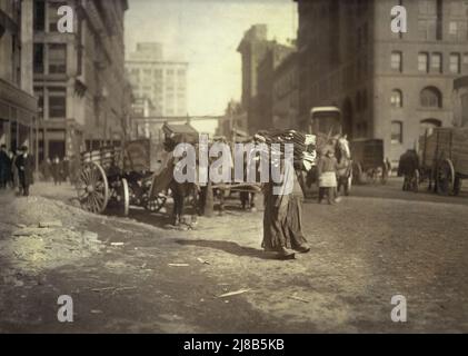 Donna che trasporta un carico pesante di vestiti sulle sue spalle, Lafayette Street sotto Astor Place, New York City, New York, USA, Lewis Wickes Hine, National Child Labor Committee Collection, febbraio 1912 Foto Stock
