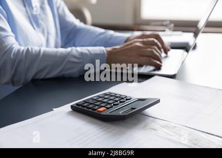 Lavoro professionale femminile con calcolatrice, documenti finanziari Foto Stock