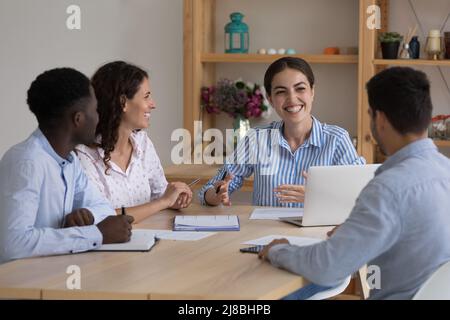 Donna felice del capo di affari che parla con il team dei dipendenti Foto Stock