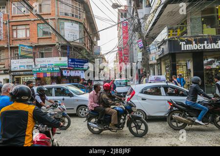 Kathmandu, Nepal - 30 ottobre 2021: Strada trafficata nella capitale del Nepal. Moto e automobili che condividono lo spazio limitato sulla strada. Elettrico Foto Stock