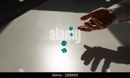 La donna lancia un paio di dadi trasparenti blu. Foto Stock