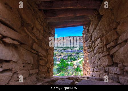 Sbirciando attraverso un lungo buco in un muro che era una finestra per la zona fuori del Bonito ad altre rovine. Foto Stock