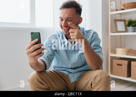 Allegro sorridente ragazzo comunicativo parlare con la famiglia utilizzando la videochiamata telefonica discute le ultime notizie piacevole alzare dito verso l'alto guarda lo schermo Foto Stock