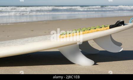 Surfboard per il surf sdraiato sulla spiaggia di sabbia, costa californiana, USA. Onde oceaniche e tavole da surf bianche o paddleboard. Longboard o sup per la ricreazione di sport acquatici con acqua di mare. Cinematografia senza giunture. Foto Stock