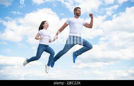 padre e figlia energici saltano nel cielo Foto Stock