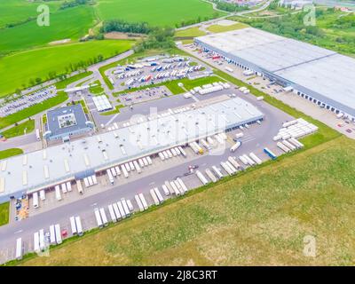 Vista aerea dei camion colorati nel terminal in attesa di scarico. Vista dall'alto del centro logistico. Trasporto. Trasporto merci, consegna. IO Foto Stock