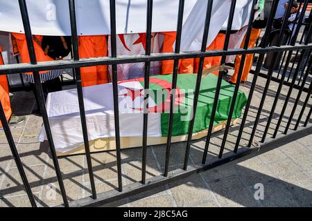 Durante la manifestazione si vede una bara coperta di bandiera algerina. Centinaia di membri della diaspora algerina marciano a Marsiglia contro la dittatura militare nel loro paese. Foto Stock