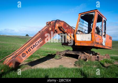 Derelitto escavatore su terreno agricolo vicino Waverly, South Taranaki, Isola del Nord, Nuova Zelanda Foto Stock