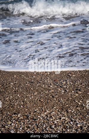 Spiaggia rocciosa vista dall'alto con una ​​wave di mare. Foto Stock