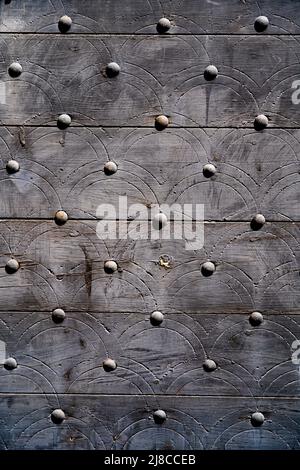 Porta in legno con bottoni tondi metallici. Foto Stock