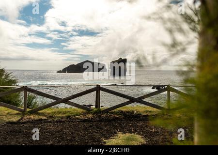 Vista panoramica delle isolette di Mosteiros all'orizzonte, scogliera con rocce nell'oceano con, São Miguel isola, Azzorre, Portogallo. Foto Stock