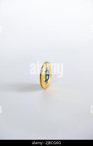 Faccia a faccia Bitcoin colore oro moneta con la lettera 'B' su colore blu, centrata su sfondo bianco. Bitcoin - BTC bit Coin - Crypto valuta. Foto Stock