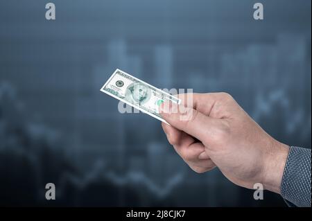 inflazione. l'uomo tiene un piccolo cento dollaro fattura in sua mano, simbolo di inflazione. concetto di potere d'acquisto decrescente, inflazione. inflazione in u Foto Stock