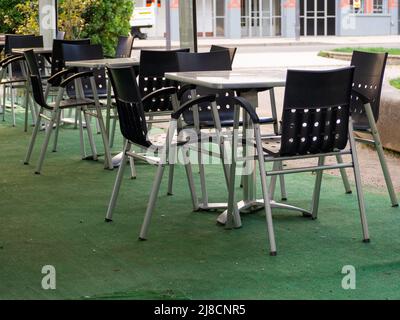 Sedie e tavoli vuoti al ristorante chiuso all'aperto per la crisi di inflazione. Foto Stock