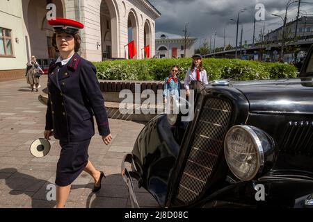 Mosca, Russia. 15th maggio 2022. Un dipendente della stazione della metropolitana in uniforme di 1930-1940 anni è visto vicino ad un ingresso alla stazione della metropolitana di Park Kultury a Mosca, Russia. La stazione di Park Kultury rienacts, in una strada prima di un ingresso alla stazione, la cerimonia del 1935 per lanciare la prima linea in assoluto per celebrare il 87th compleanno della metropolitana di Mosca, Russia. Nikolay Vinokurov/Alamy Live News Foto Stock