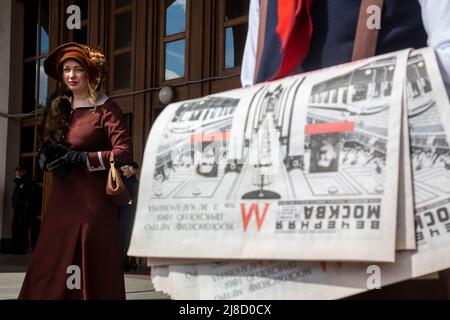 Mosca, Russia. 15th maggio 2022. Il giornale Vechernaya Moskva 14 maggio 1935 numero con le informazioni circa l'apertura della metropolitana a Mosca. La stazione di Park Kultury rienacts, in una strada prima di un ingresso alla stazione, la cerimonia del 1935 per lanciare la prima linea in assoluto per celebrare il 87th compleanno della metropolitana di Mosca, Russia. Nikolay Vinokurov/Alamy Live News Foto Stock