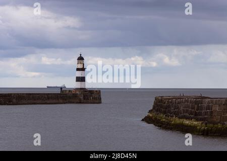 Iconico faro Seaham a righe sul molo con nuvole e pareti marine Foto Stock