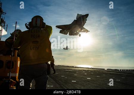 Un velivolo da caccia U.S. Marine Corps F-35B Lightning II, attaccato ai draghi di Marine Medium Tiltrotor Squadron 265, esegue un atterraggio verticale sul ponte di volo della nave d'assalto anfibio di classe americana USS America durante un esercizio di difesa aerea, 23 marzo 2020 operante sul Mare delle Filippine. Foto Stock