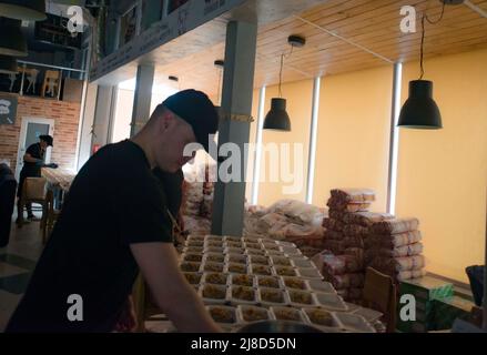 Kharkiv, Ucraina. 15th maggio 2022. Volontari dell'industria della ristorazione di Kharkiv, che preparano cibo per le persone bisognose, che hanno perso il reddito o la positività di cucinare, a seguito dell'invasione russa e della distruzione della città. I volontari fanno migliaia di porzioni ogni giorno. Credit: Gusty/Alamy Live News Credit: Gusty/Alamy Live News Foto Stock