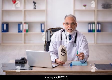 Medico anziano in concetto di remunerazione Foto Stock