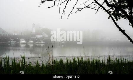 NORWALK, CT, USA - 15 MAGGIO 2022: Bella nebbia mattutina vicino al centro con bassa marea nel fiume Norwalk Foto Stock