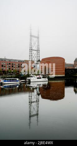 NORWALK, CT, USA - 15 MAGGIO 2022: Bella nebbia mattutina vicino al centro con acquario marittimo, barche e ponte ferroviario Foto Stock