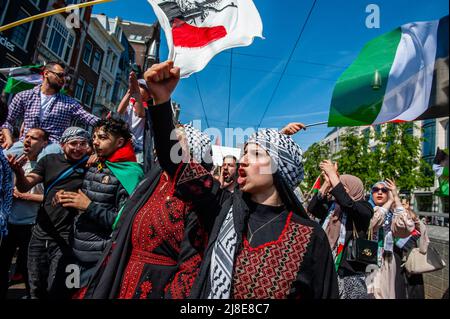 I manifestanti palestinesi cantano slogan a sostegno della Palestina e contro Israele durante un raduno in occasione del 74th° anniversario della Giornata di Nakba in piazza Dam ad Amsterdam. I manifestanti palestinesi si sono riuniti per un raduno in piazza Dam ad Amsterdam in occasione del 74th anniversario della Nakba Day e per condannare l'assassinio del giornalista palestinese-americano Shireen Abu Akleh da parte delle forze israeliane. La parola “Nakba” significa “catastrofe” in arabo, e si riferisce alla pulizia etnica sistematica di due terzi della popolazione palestinese all’epoca da parte dei paramilitari sionisti tra il 1947-1949 e il Th Foto Stock