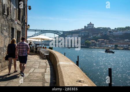 I turisti sono visti facendo una passeggiata lungo le rive del fiume Douro, a Porto. Foto Stock