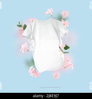 T-shirt in cotone bianco fluttuante su sfondo blu. Composizione concettuale di una maglietta unisex bianca e fiori nell'aria. Vista frontale dei vestiti con marchio Foto Stock