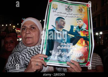 Nablus, Palestina. 15th maggio 2022. Una donna palestinese dimostratrice ha un poster di Daoud al-Zubaidi durante una protesta a seguito della sua morte a Nablus. Daoud al-Zubaidi, morì il 15.05.2022 in un ospedale di occupazione israeliano a Haifa a causa delle ferite subite dalle forze di occupazione israeliane nel campo di Jenin, occupato in Cisgiordania. Credit: SOPA Images Limited/Alamy Live News Foto Stock