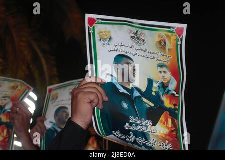 Nablus, Palestina. 15th maggio 2022. Un palestinese detiene un poster di Daoud al-Zubaidi durante una protesta a seguito della sua morte a Nablus. Daoud al-Zubaidi, morì il 15.05.2022 in un ospedale di occupazione israeliano a Haifa a causa delle ferite subite dalle forze di occupazione israeliane nel campo di Jenin, occupato in Cisgiordania. Credit: SOPA Images Limited/Alamy Live News Foto Stock