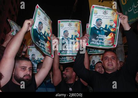 Nablus, Palestina. 15th maggio 2022. I palestinesi detengono poster di Daoud al-Zubaidi durante una protesta a seguito della sua morte a Nablus. Daoud al-Zubaidi, morì il 15.05.2022 in un ospedale di occupazione israeliano a Haifa a causa delle ferite subite dalle forze di occupazione israeliane nel campo di Jenin, occupato in Cisgiordania. Credit: SOPA Images Limited/Alamy Live News Foto Stock