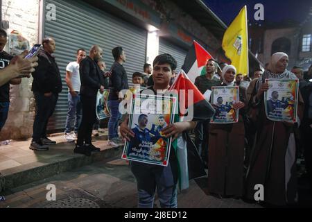 Nablus, Palestina. 15th maggio 2022. Un giovane palestinese tiene un poster di Daoud al-Zubaidi durante una protesta a seguito della sua morte a Nablus. Daoud al-Zubaidi, morì il 15.05.2022 in un ospedale di occupazione israeliano a Haifa a causa delle ferite subite dalle forze di occupazione israeliane nel campo di Jenin, occupato in Cisgiordania. Credit: SOPA Images Limited/Alamy Live News Foto Stock